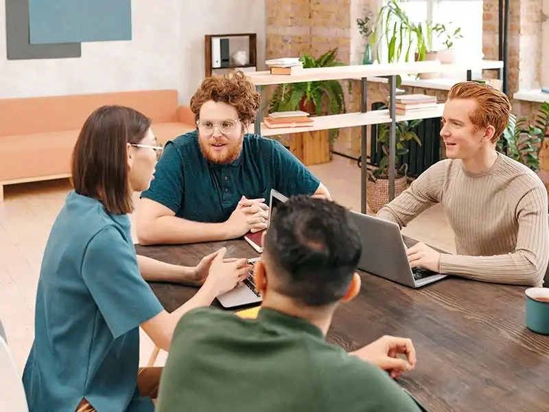 Group of honor professionals sit at table and discuss a solution